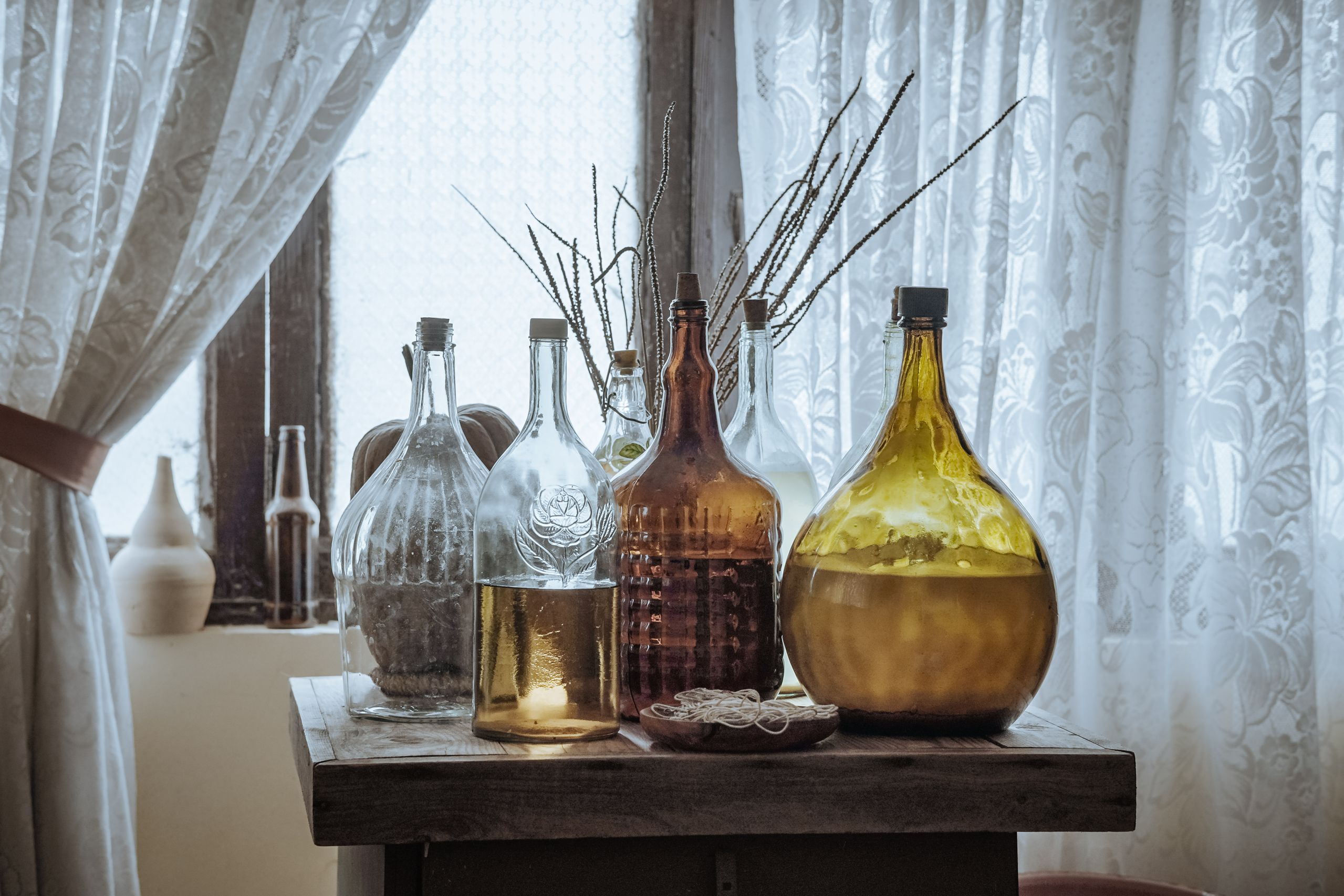 Vase with ferns and amber bottles