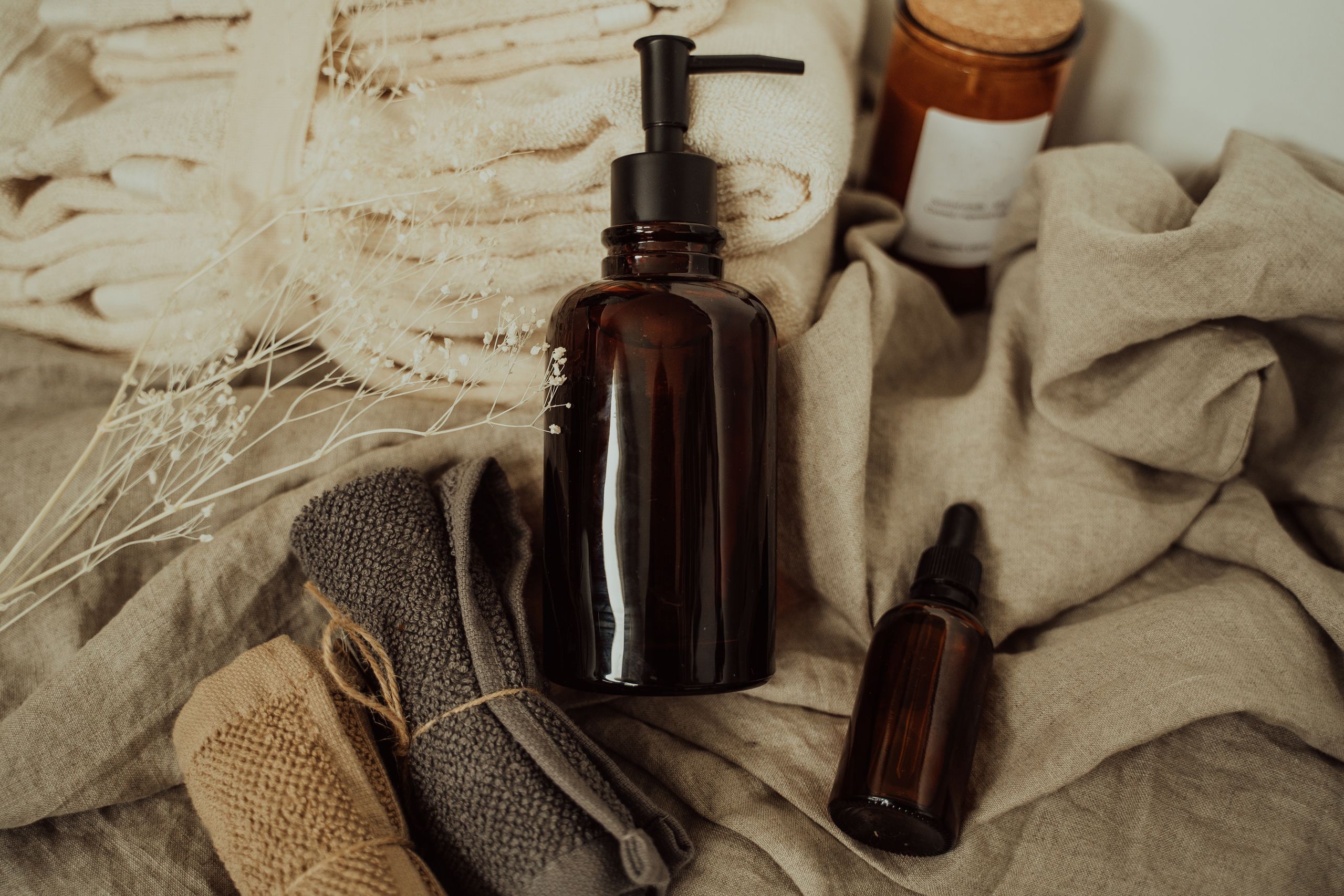 vase with ferns, amber bottles, and towel