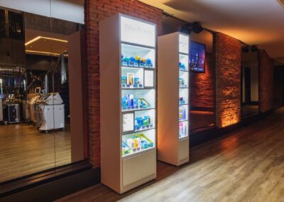 Illuminated cosmetic display shelves in a stylish spa with brick accents and ambient lighting.