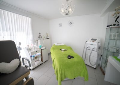 Interior of workplace of cosmetology clinic equipped with medical appliances with medicines and couch for massage
